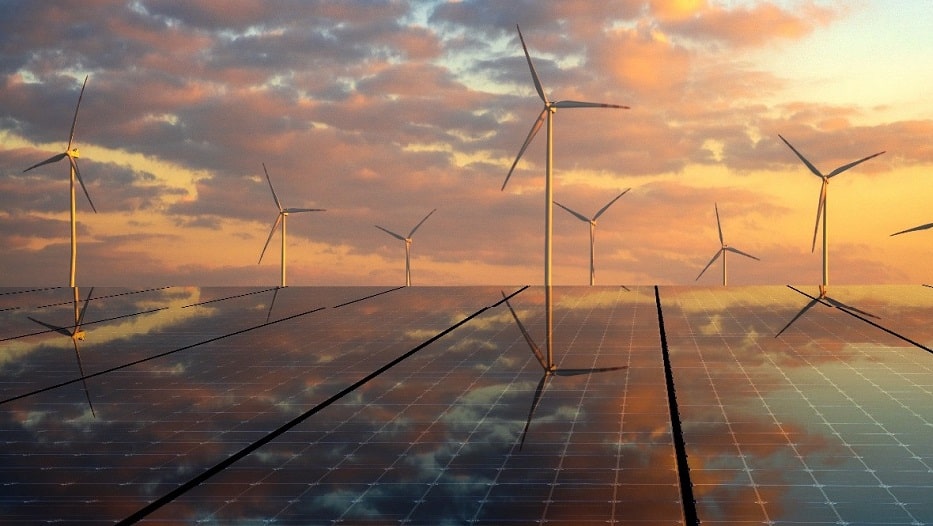 Aerogeneradores en el atardecer junto a placas solares