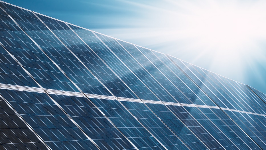 Solar power plant panels with sun rays and blue sky