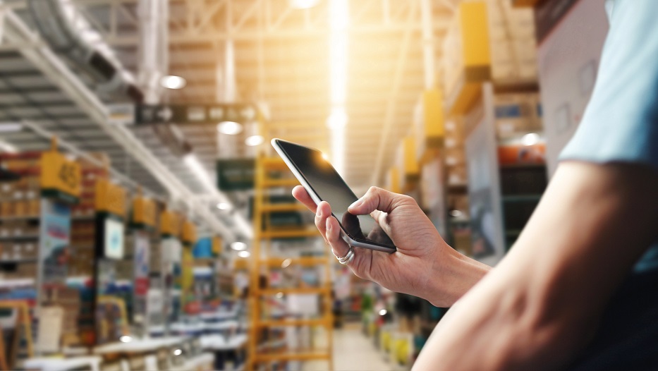 Factory worker using application on mobile smartphone to operate automation for modern trade. Checking order in large warehouse. Import and export the shipping cargo.